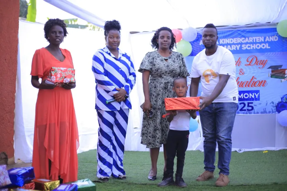 Adults standing together in front of a school event backdrop.