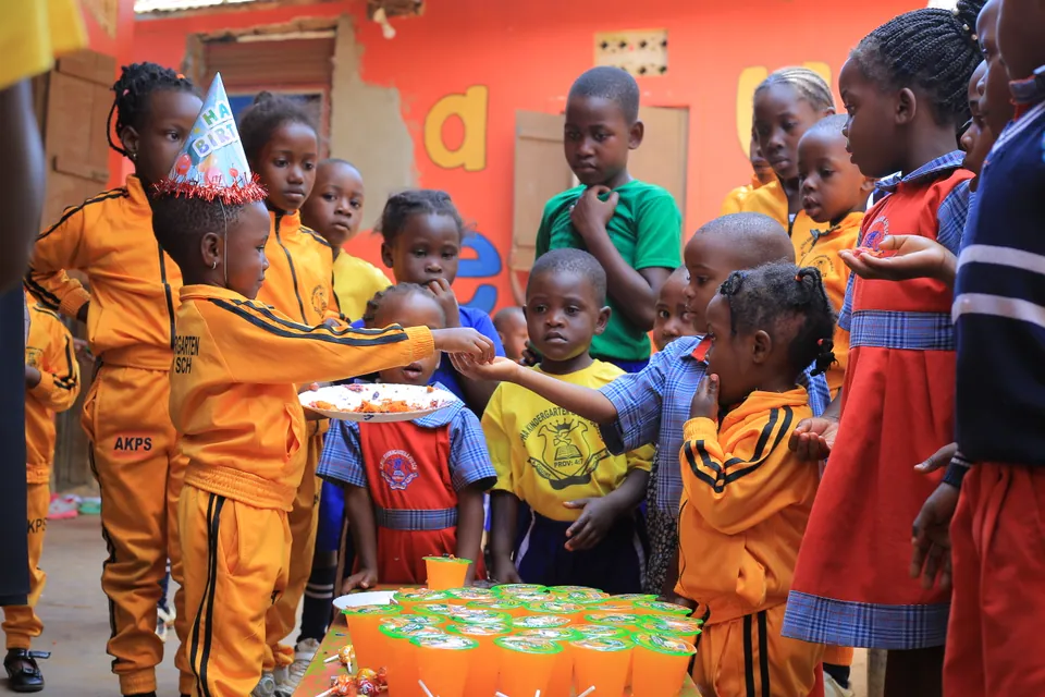 Children sharing cake during a school celebration.
